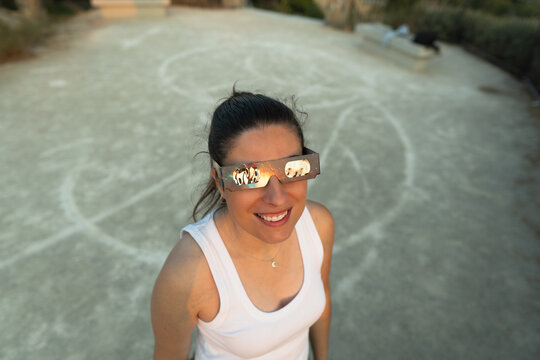 Woman observing solar eclipse wearing protective glasses