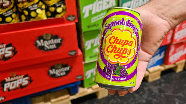 Hand holding chupa chups sparkling grape beverage can
