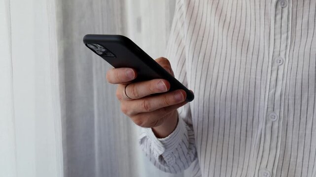 Man using smartphone at home for mobile communication and online browsing.