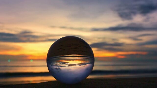 Ocean Sunset Through the Crystal Orb. The world pauses within the glass, where dusk unfolds in miniature perfection. A golden horizon dances upside down, framed by a sphere of clarity.
