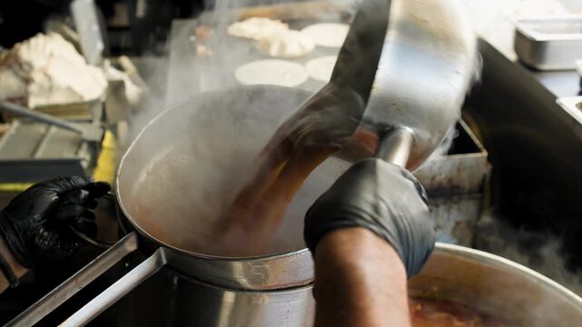 Birria cooking footage showing adding birria soup into strainer during the traditional Mexican birria cooking process