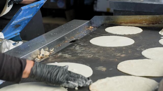 Traditional cooking footage showing slow motion of multiple tortillas being flipped during preparation of fresh handmade corn tortillas