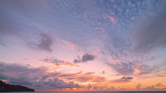 Stunning time lapse footage of a tropical beach at sunset, featuring textured clouds shifting across a colorful sky while waves gently crash onto the sandy shore. Ideal for themes of vacation