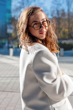 Confident businesswoman looking back with elegant professional style outdoors. 