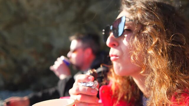 Hiking snack woman sunglasses enjoying a peaceful moment while eating chocolate outdoors during a sunny adventure in nature