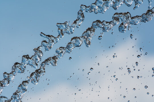 Splashes and jets of water against light background.