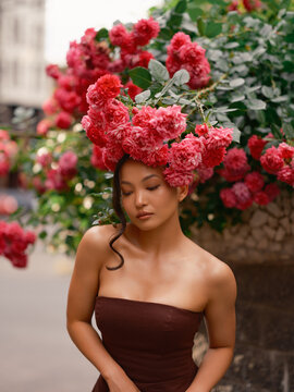 Portrait beautiful Asian woman under blooming roses