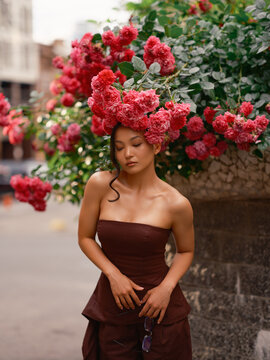 Portrait beautiful Asian woman under blooming roses