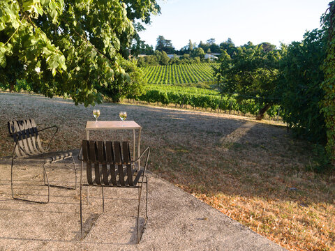 Beautiful view of vineyards at Monbazillac village, France.Romantic setting with two glasses of wine, tables and chairs looking out over an Idyllic and picturesque rural French landscape in Aquitaine.