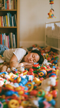 An exhausted young Asian mother sleeping soundly on the floor