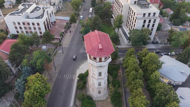 Cinematic aerial drone orbit around the historic Chisinau Water Tower, home to the City History Museum, revealing its distinctive architecture and surrounding streets of central Chisinau, Moldova.