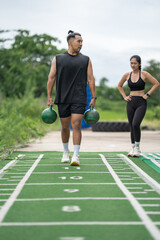 Obraz premium Asia man carrying kettlebells on running track