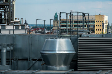 Industrial rooftop ventilation system with Lublin city skyline and church towers. © Anastazja