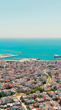 Vertical video. Alexandroupolis, Greece. Panorama of the central part of the city in summer. Coast of the Thracian Sea. Drone footage. Rich colors