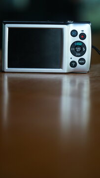 Vertical Shot of Vintage Compact Digital Camera on Wooden Table