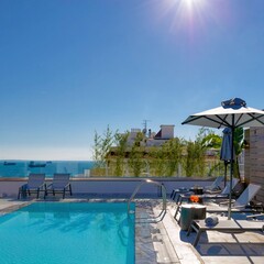 Fototapeta premium Modern Rooftop Infinity Pool with Ocean View and Relaxing Lounge