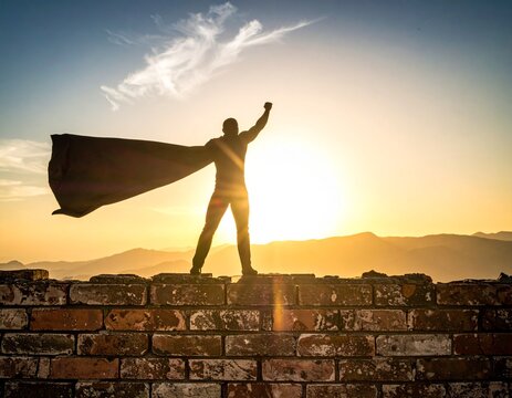 Giant superhero shadow on a brick wall for inner strength and potential concepts
