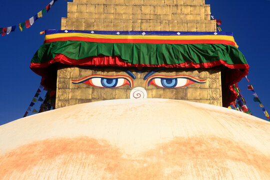Boudhanath Stupa decorated with colorful Buddhist prayer flags against a deep blue sky in Kathmandu, Nepal