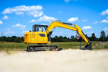 Mini excavator working at a construction site, digging and moving soil. Compact heavy machinery used for excavation, landscaping, and site preparation. © senssnow