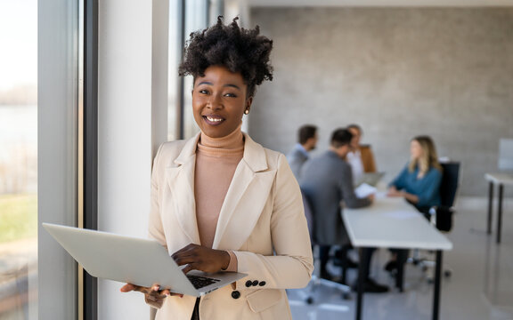 Happy multiethnic businesspeople laughing while collaborating on a new project in an office.