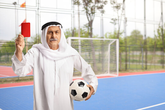 Middle eastern man in ethnic clothes holding a football