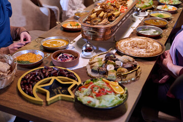 Obraz premium Gathering of family and friends at a traditional iftar feast during Ramadan in a cozy dining space