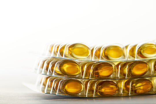 Yellow softgel vitamin capsules in blister packs
