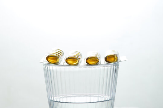 Softgel capsule blister pack on a glass of water