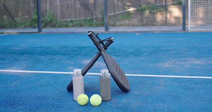 Cam is adjusting frame to steady while paddles balls bottles are staying centered on blue court