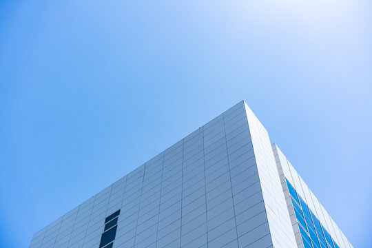 Glass Facade Office Building Under Blue Sky for Modern Architecture Corporate Vision and Real Estate Investment Background, Low Angle Perspective Photo with Copyspace