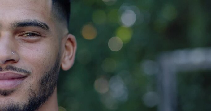 Adult man reacting to offscreen cue, smiling, laughing in yard showing teeth, nose stud, copy space