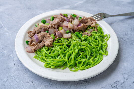 A plate of stir-fried noodles with beef and onions