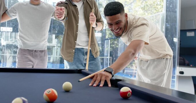 Diverse male friends watching shooter leaning lining cue striking at pool table during casual game