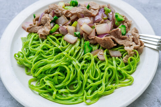A plate of stir-fried noodles with beef and onions