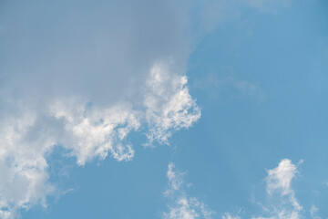Clouds drift in the blue sky above on a clear day with sunlight shining through the wispy clouds © Jill Dundee