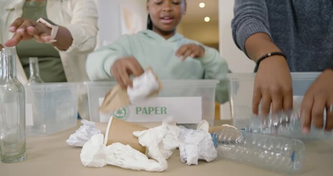 Family sorting recyclables after spotting pile, placing glass paper plastic into labeled bins