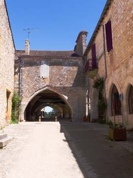 Monpazier village - Dordogne - France - July 6 2026 : Charming medeival bastide town in southwest France. View of one of the arched entrances to the historic old market square.