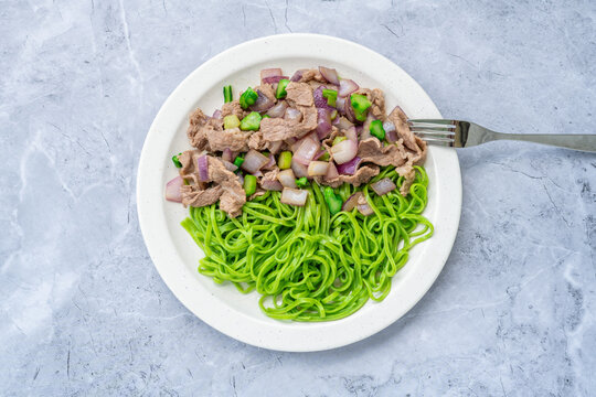 A plate of stir-fried noodles with beef and onions