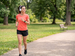 Fototapeta premium Young fair white woman jogging outdoors for weight loss fitness wellness exercise motivation healthy lifestyle and preventive healthcare advertising campaign
