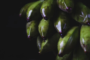Fresh green bananas on the dark background © Thai