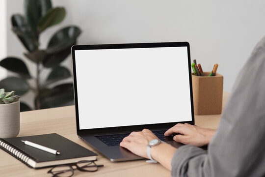 Young woman using laptop with blank empty mockup screen, female hands typing on computer keyboard closeup. Working or studying from home office, shopping online, web site design concept