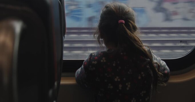 Girl looks out the window of a train heading to Toronto airport