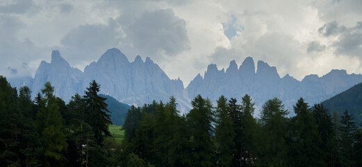 Obraz premium Majestic scenery of rough mountain ridge near grassy hills 