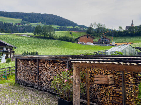  traditional alpine village, featuring rustic wooden buildings and lush green mountain slopes under a bright blue sky