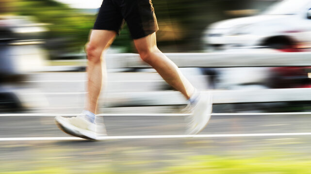 Athlete running at high speed with dramatic motion blur on an outdoor road