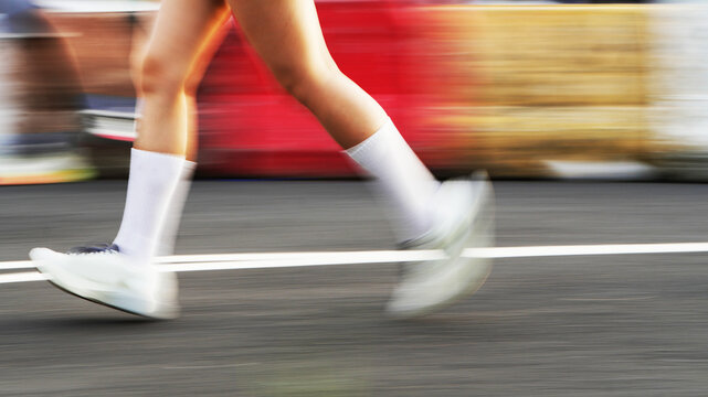 Creative motion blur photograph of a runner moving through a bright outdoor environment