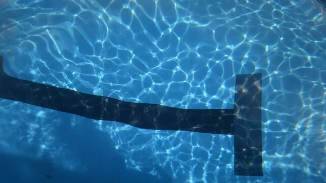 Swimming pool water rippling over lane marker in daylight