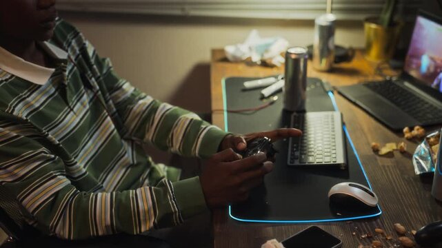 African American teenager playing video game, losing match and holding head in frustration during handheld zoom out. Clip is perfect for screen addiction and mental health campaigns