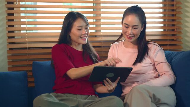 Daughter Teaching Mother How to Use Statistics on Tablet at Home on Mother's Day