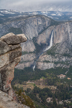 Vertical view of Yosemite valley canyon and waterfalls from Glacier Point overhanging rock